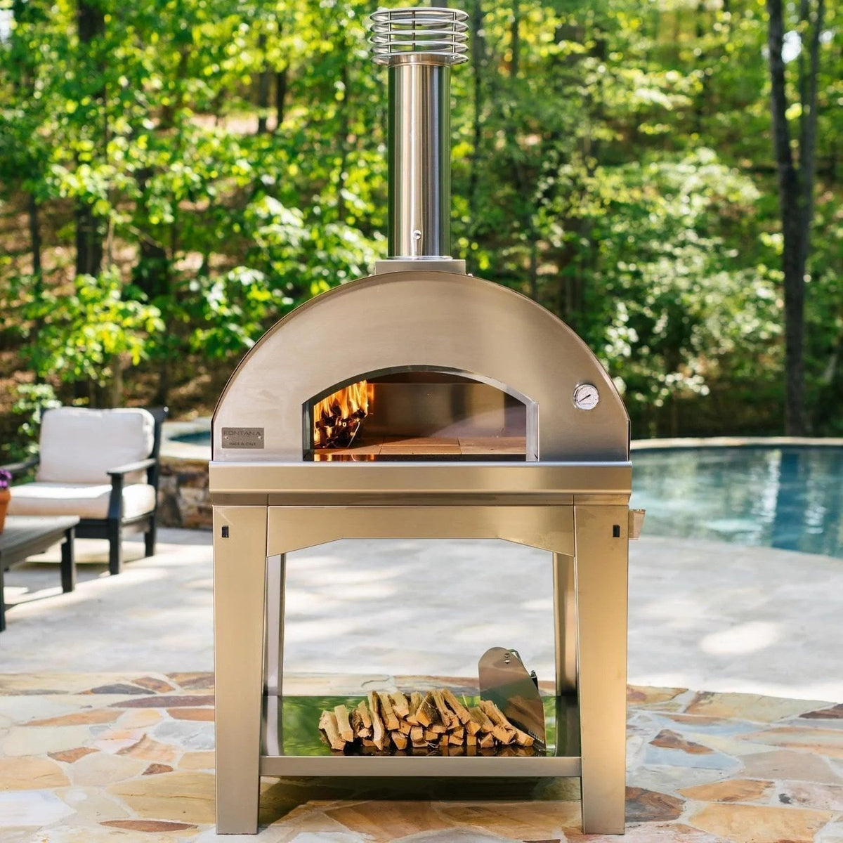 Casavibeo Fontana Forni Mangiafuoco wood-fired pizza oven in anthracite with brick interior and stainless steel chimney visible.
