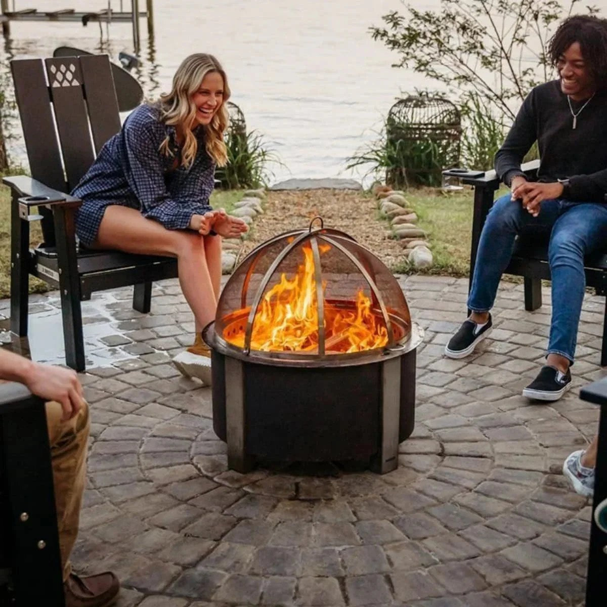 Casavibeo X Series 28-inch round cortens steel wood-burning fire pit in stainless steel, shown with flames and logs inside.