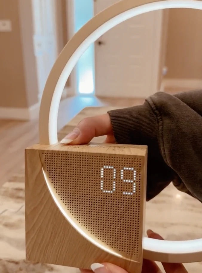 Belro Sunrise Simulation Alarm Clock displaying a bright, sunrise-like light with digital time on a bedroom bedside table.