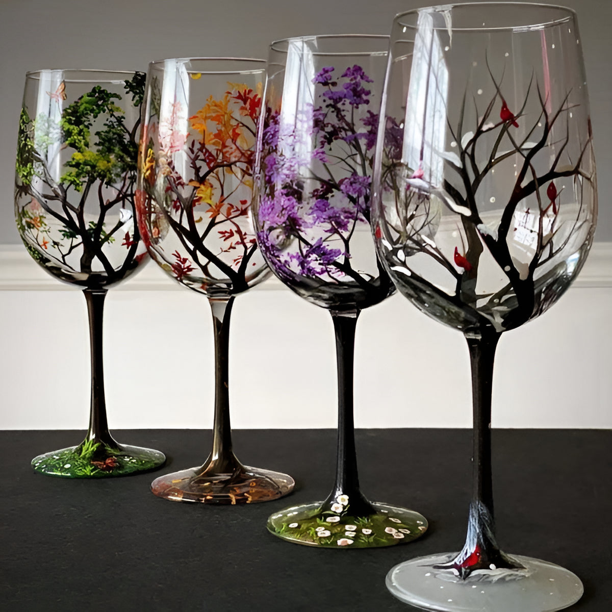 Hand-painted Four Seasons Tree wine glasses by Belro, showcasing colorful seasonal artwork on elegant glassware.