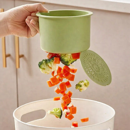 Mivoza hanging drain basket with two-part filter and one-click empty sink organizer in a kitchen sink.