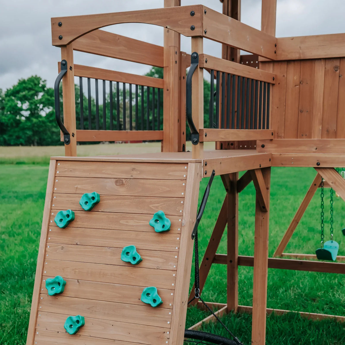 Casavibeo Sterling Point swing set with rock wall for backyard play, featuring colorful climbing holds and durable wooden frame.