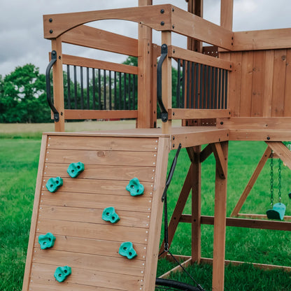Casavibeo Sterling Point swing set with rock wall for backyard play, featuring colorful climbing holds and durable wooden frame.