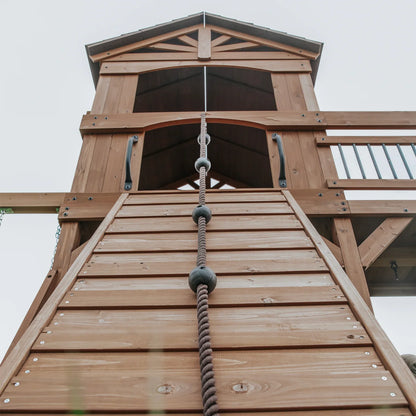 Casavibeo Sterling Point swing set with rope wall for backyard play, featuring sturdy wooden frame and colorful climbing elements.