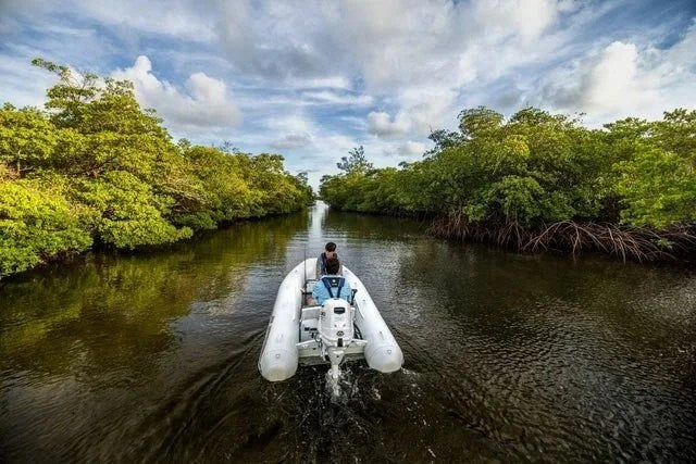 Suzuki 30 HP outboard motor DF30ATLW5 mounted on boat, showcasing the compact, lightweight design and sleek black finish.