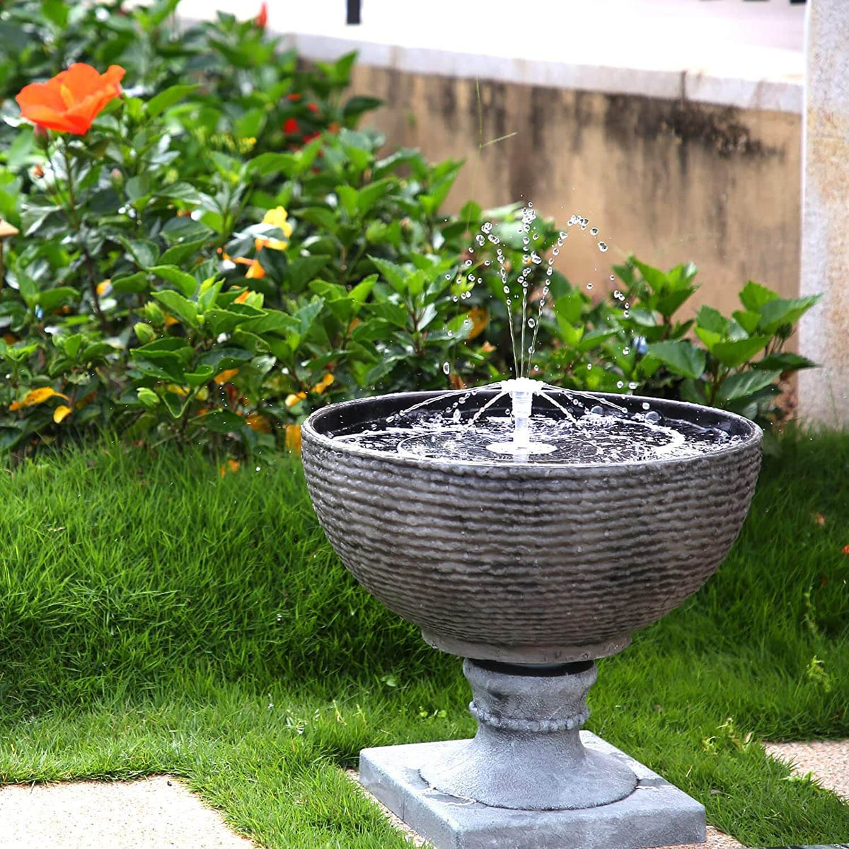Belro LED solar energy fountain in a garden setting, showcasing water flowing and illuminated by built-in LED lights for outdoor decor.