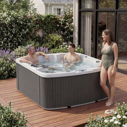 Casavibeo Lifesmart Leganza 6-person spa with 90 jets, lounge seating, in coastal gray, featuring people relaxing in a backyard setting.