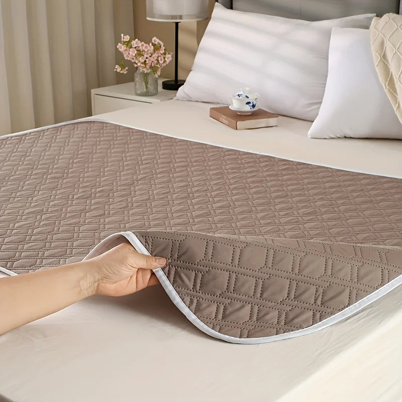 Belro washable incontinence bed protector spread out on a bed, soft waterproof fabric and absorbent layer visible.