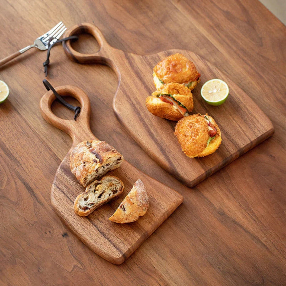 Set of two walnut wooden cutting boards with loop handles for hanging, perfect for kitchen prep and display.