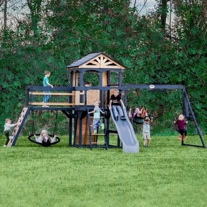 Casavibeo Timber Crossing Swing Set in backyard with swings, slide, and climbing elements on a grassy area.