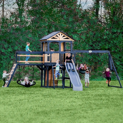Casavibeo Backyard Discovery Timber Crossing Swing Set with swings, slides, and climbing features in a backyard setting.