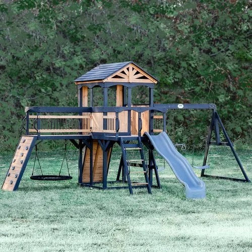 Casavibeo Timber Crossing Swing Set in backyard, featuring swings, slide, and climbing elements for outdoor play.