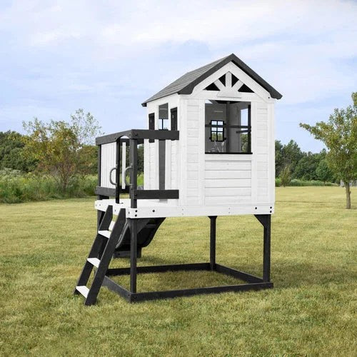 Casavibeo Backyard Discovery Sweetwater Heights elevated playhouse with slide, climbing wall, and outdoor play features in a lush backyard setting.