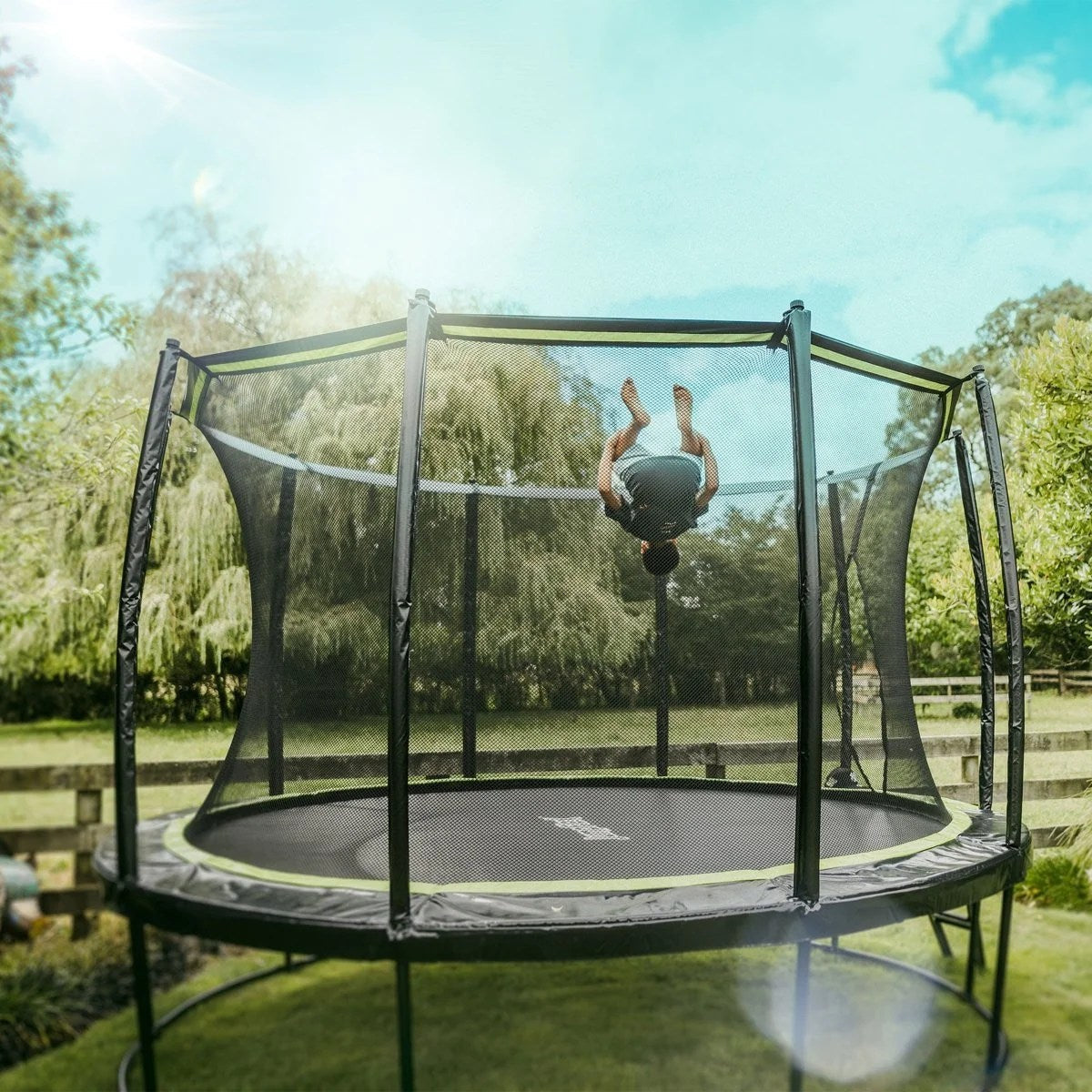 Casavibeo JumpFlex Hero Round Outdoor Backyard Trampoline with safety enclosure and sturdy frame, set up in a backyard.