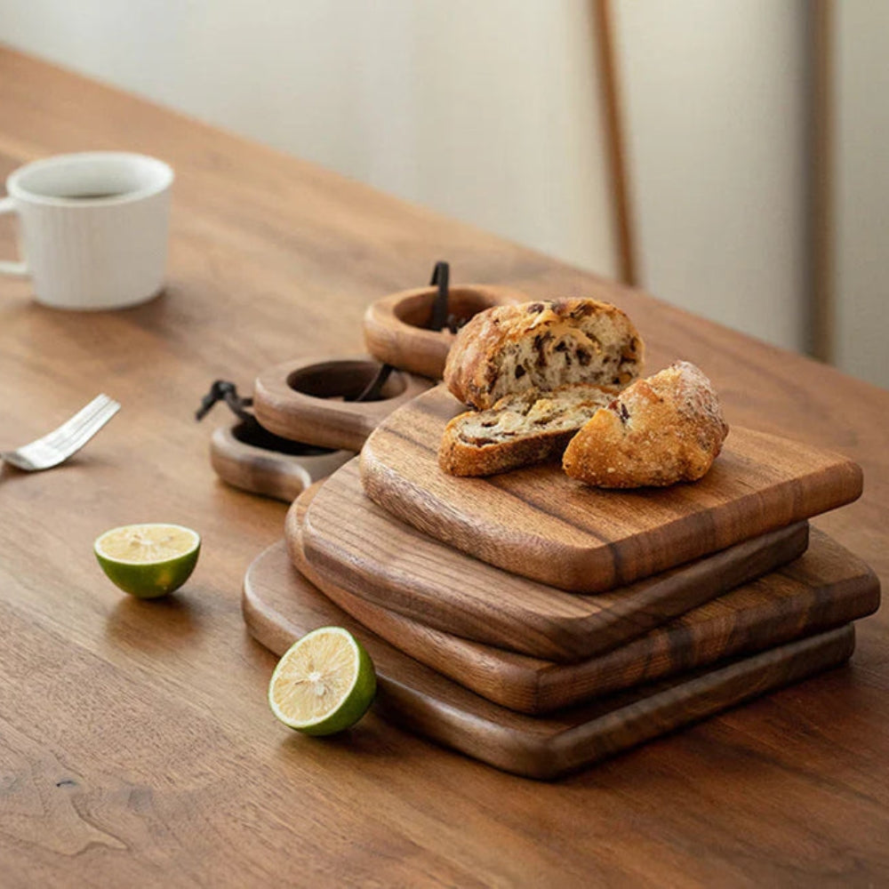 Set of two walnut wooden cutting boards with loop handles for hanging, ideal for kitchen food prep and display.