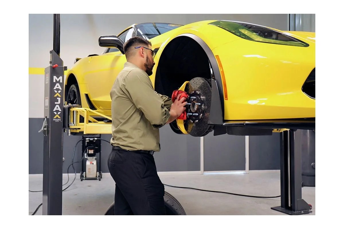 Casavibeo MaxJax portable two-post garage lift with sturdy metal arms and hydraulic lifting mechanism for vehicle maintenance.