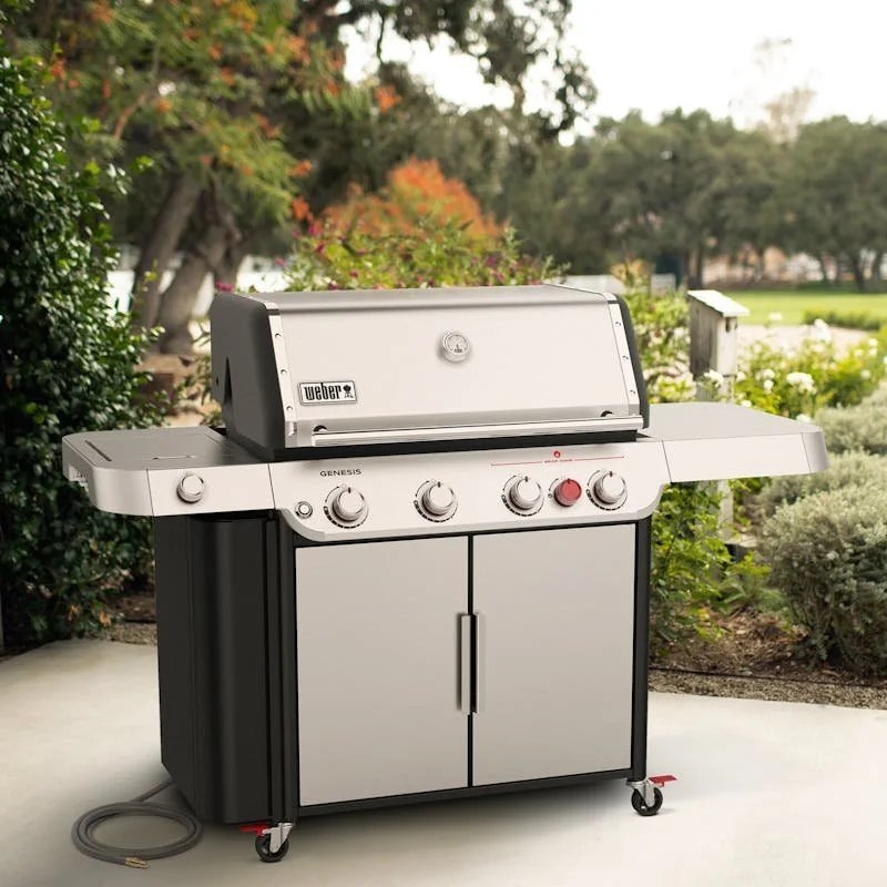 Casavibeo Weber Genesis 4-Burner Natural Gas Grill with stainless steel lid and side shelves, set up in an outdoor cooking area