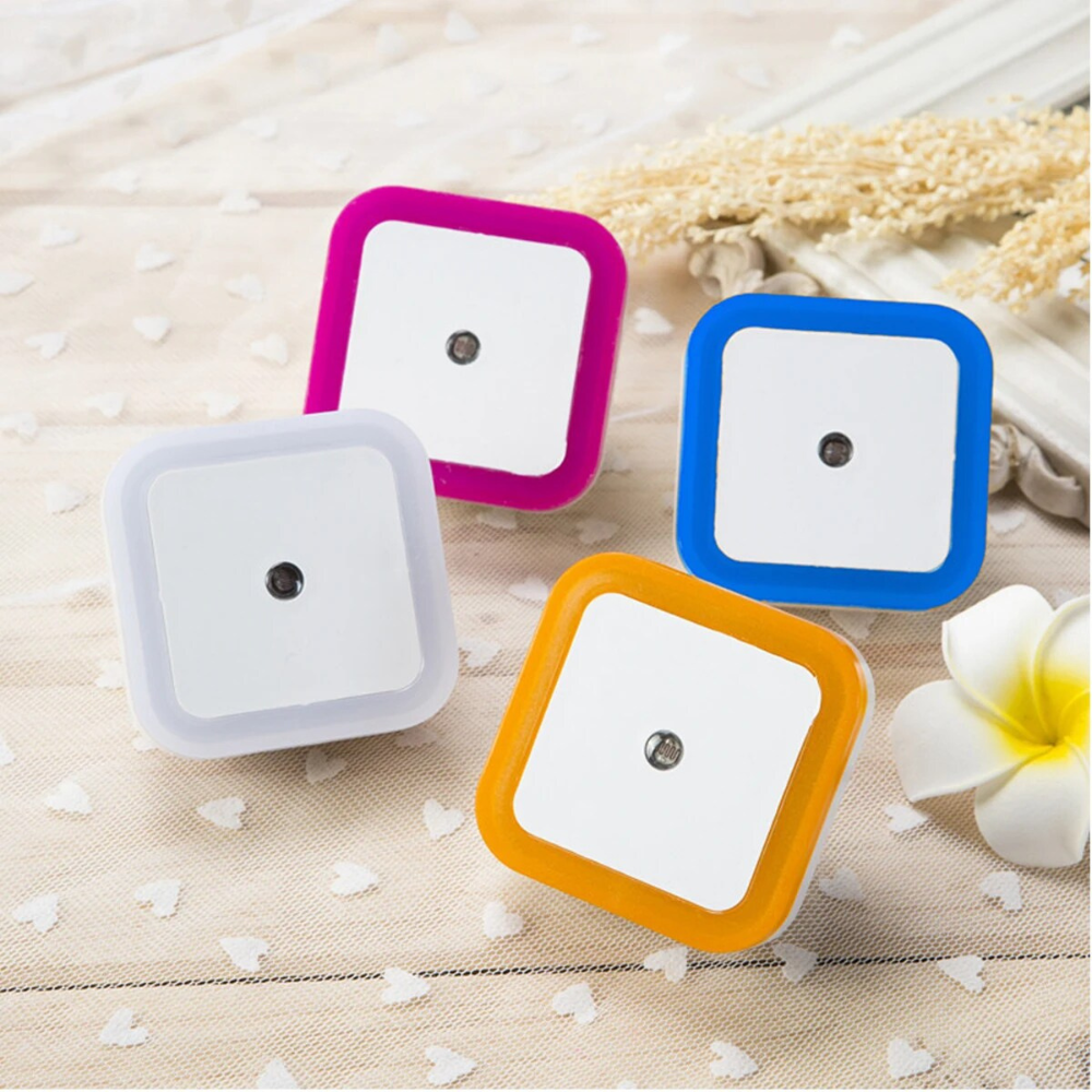 Belro plug-in motion detector smart outlet night light plugged into an electrical socket, illuminating a dark room.