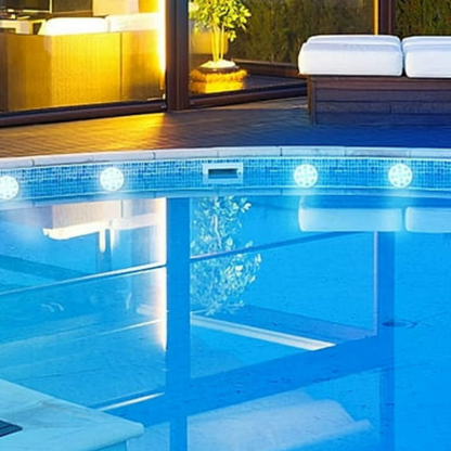 Colorful Belro submersible LED pool party lights floating in a pool, illuminating the water with vibrant colors for outdoor entertainment.