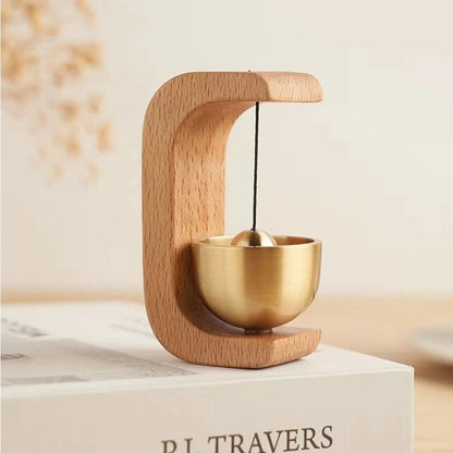 Wireless door chime by Belro with brass bell and wooden frame, featuring a sleek smart home design and traditional bell sound.