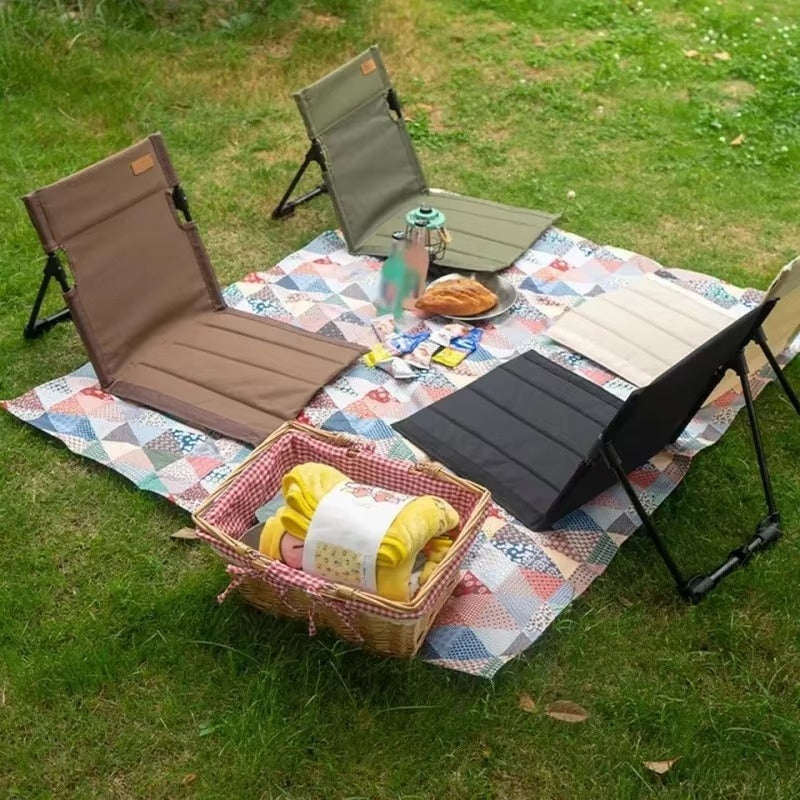 Mivoza foldable garden floor chair with back support, ideal for camping and picnics, shown in a natural outdoor setting.