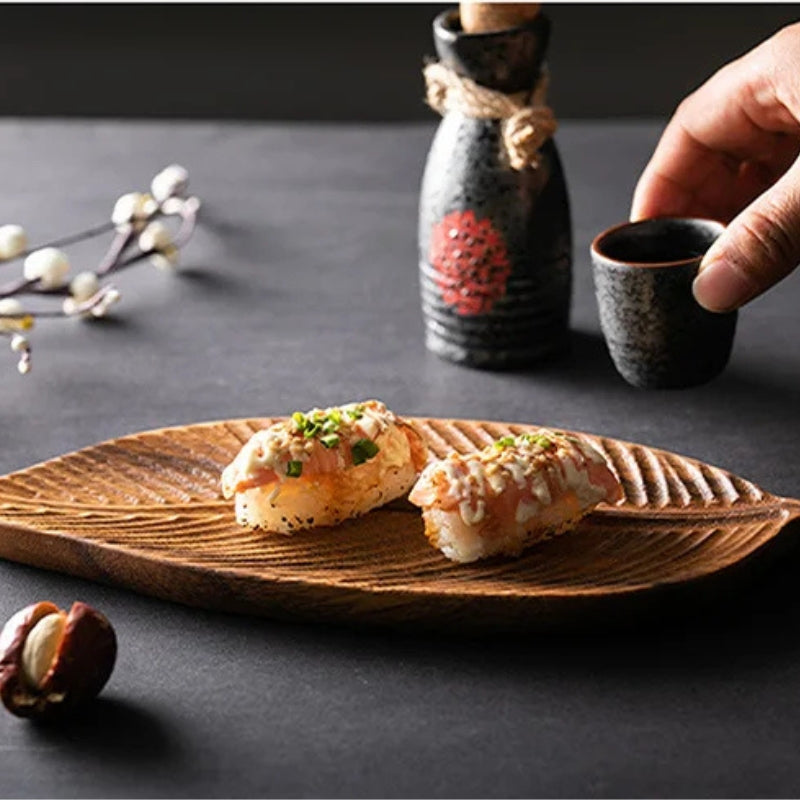 Wooden leaf serving tray by Mivoza with carved decorative design and handles, ideal for serving food and beverages.
