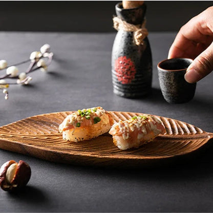 Wooden leaf serving tray by Mivoza with carved decorative design and handles, ideal for serving food and beverages.