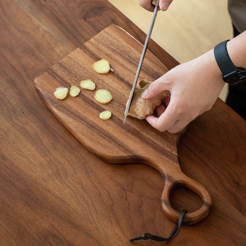Set of two walnut wooden cutting boards with loop handles for hanging, ideal for kitchen food prep and serving.