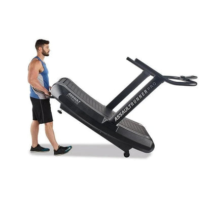 Assault Fitness AssaultRunner Pro treadmill with a black running belt and digital display, used in a gym setting.