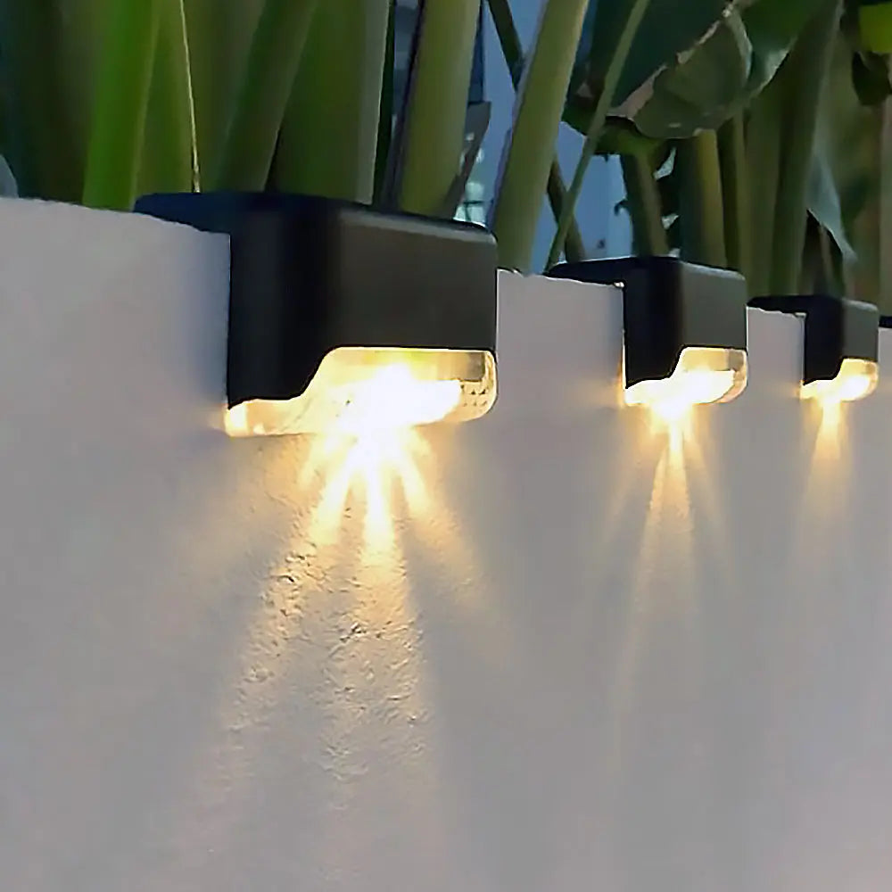 Set of four Mivoza solar patio lights showing weatherproof outdoor garden lights with automatic on/off function in a garden setting.