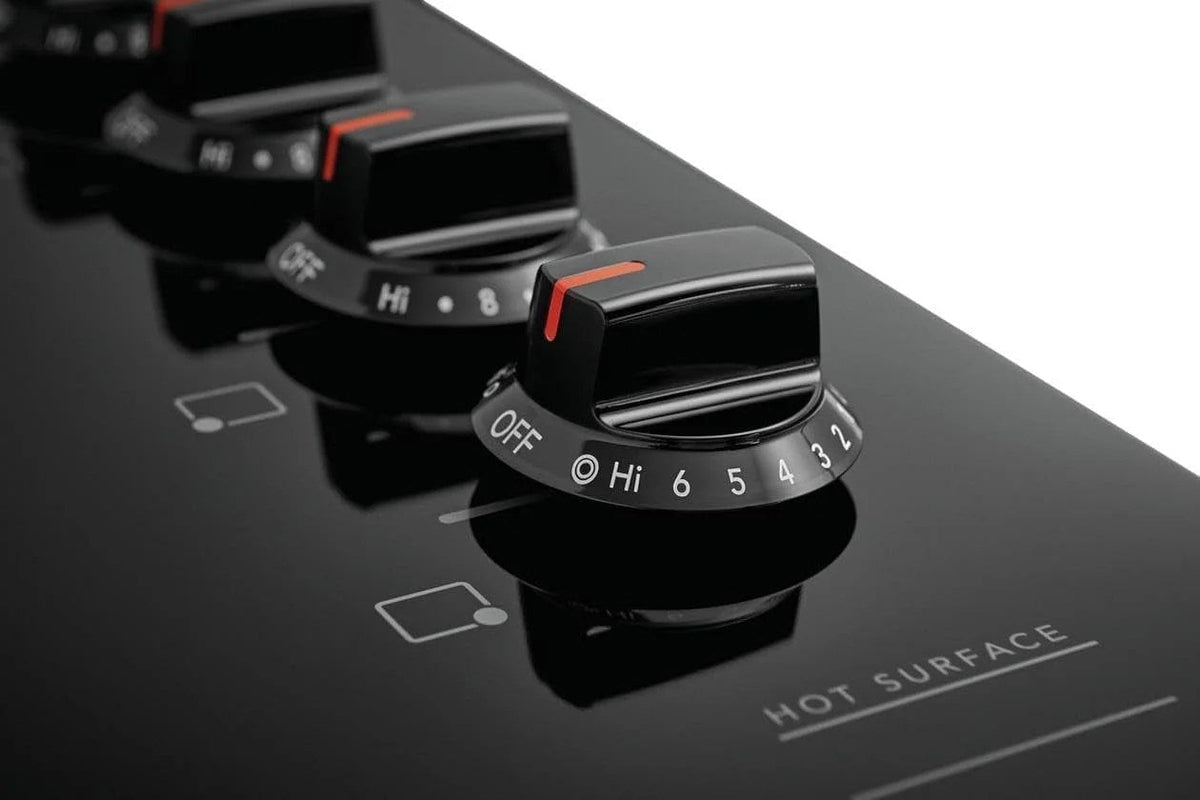 Casavibeo electric cooktop with four burners, black glass surface and control knobs for precise cooking.