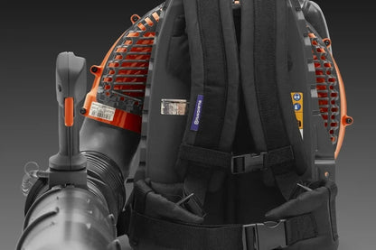 Husqvarna 580BTS gas backpack blower with ergonomic harness and powerful engine, shown in a yard setting.