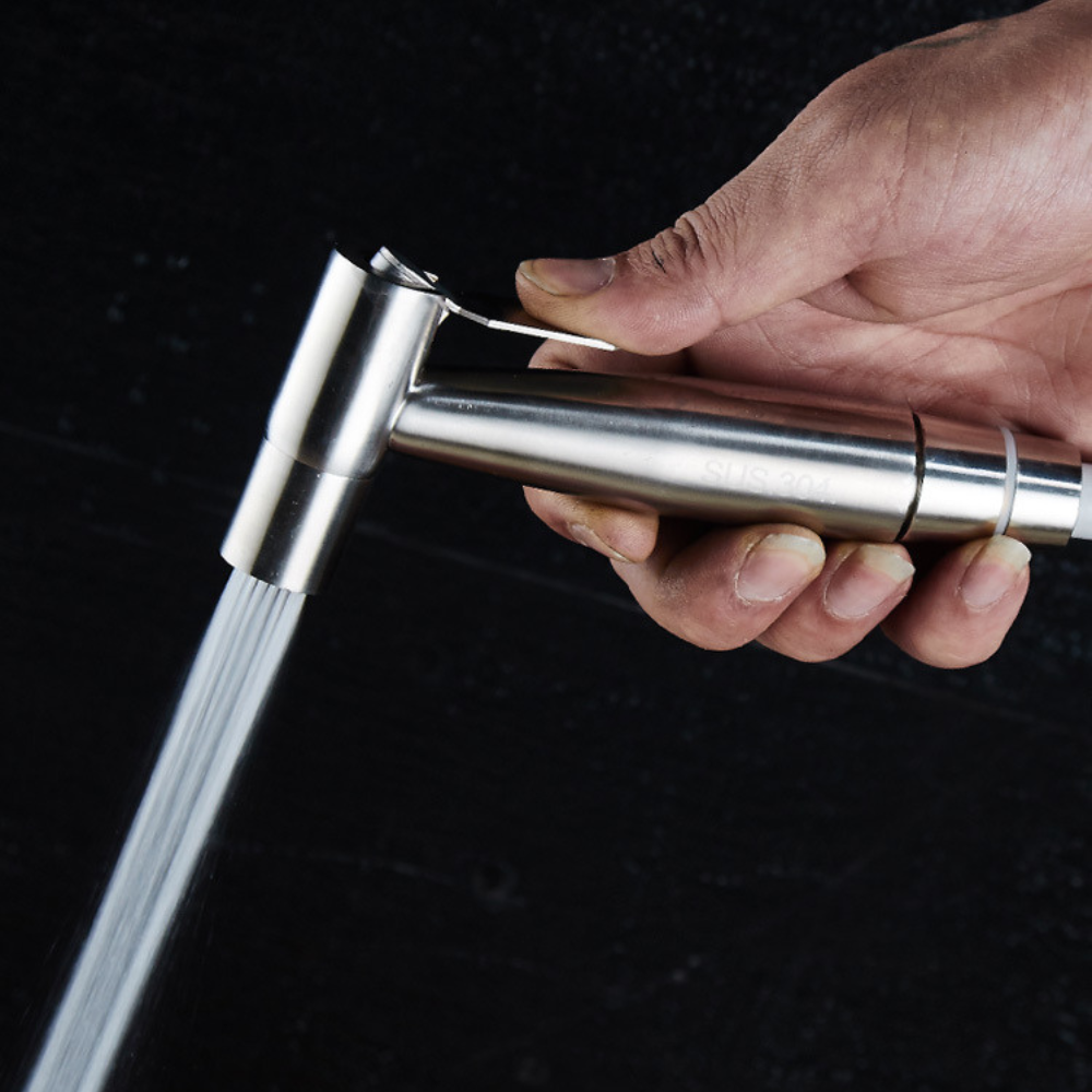 Belro handheld self-cleaning toilet bidet spray attachment mounted on a bathroom wall, demonstrating its ergonomic design and spray nozzle.
