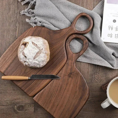 Set of two walnut wooden cutting boards with loop handles for hanging, ideal for kitchen food prep and presentation.