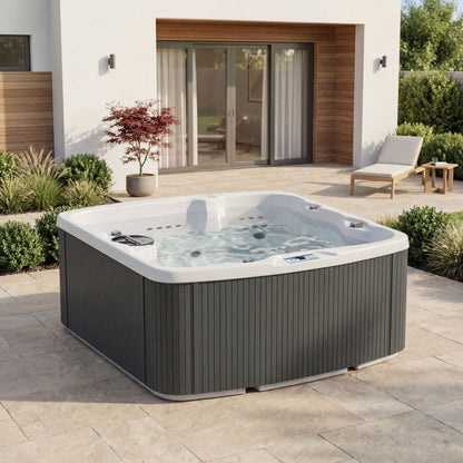Casavibeo Lifesmart Leganza 6-person spa with 90 jets, lounge seating, in coastal gray outdoor setting.