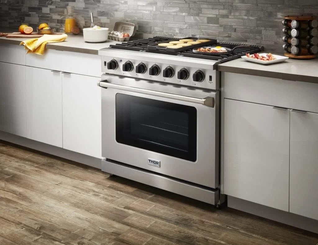 Casavibeo Thor Kitchen 36-inch gas range with four burners and stainless steel finish, front control knobs, and oven door.