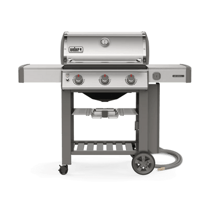 Casavibeo Weber Genesis II S-310 gas grill with stainless steel lid and side shelves, showing four burners and control knobs.