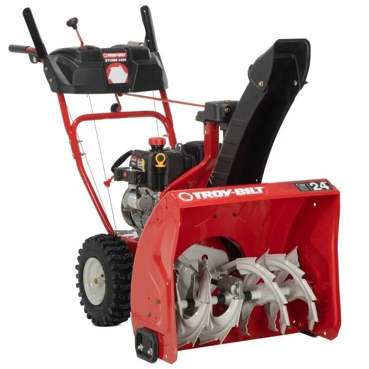 Casavibeo Troy-Bilt Storm 24-inch two-stage gas snow blower with large auger and ergonomic handle in action on snowy driveway.