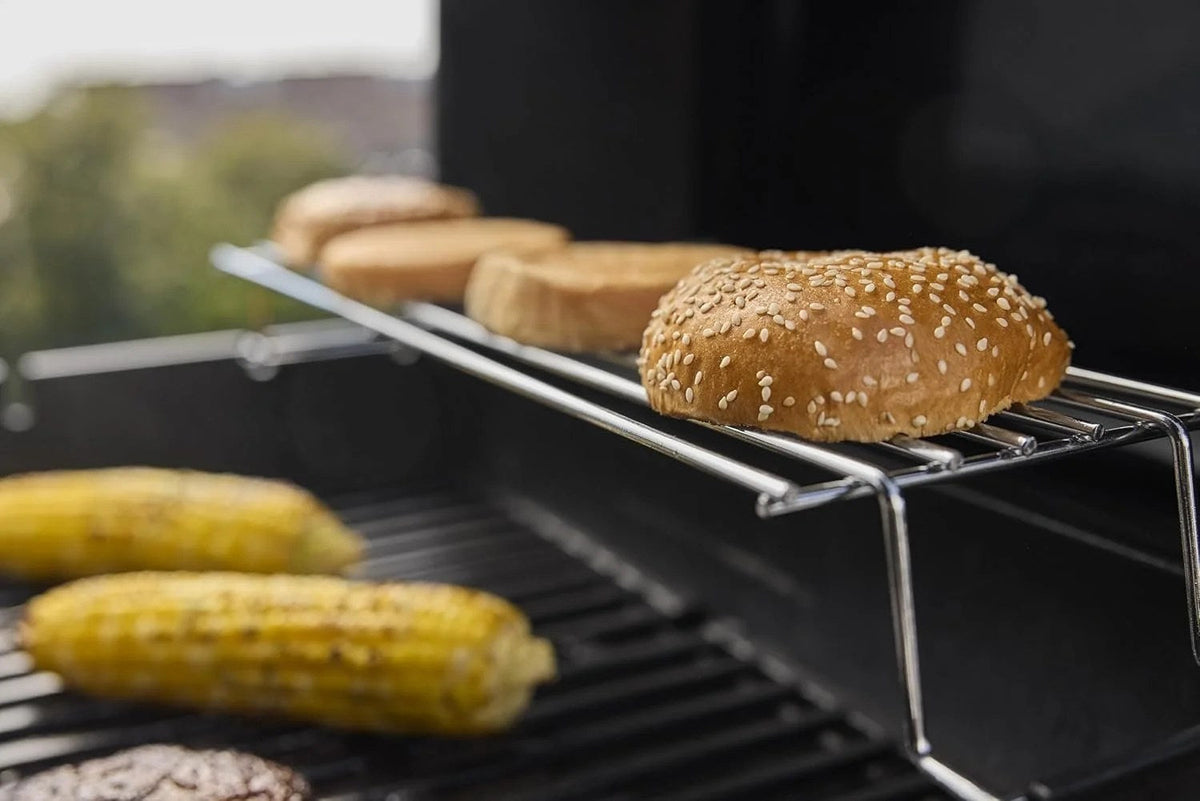 Casavibeo Weber Spirit E-325 gas grill with stainless steel lid, control knobs, side shelves, and grilling grates.