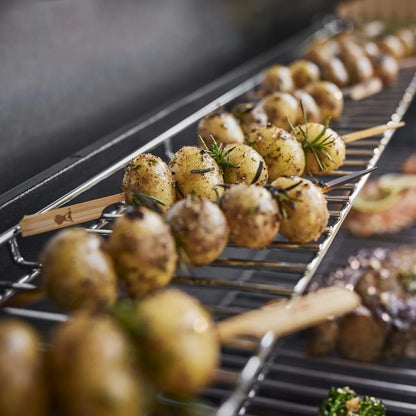 Casavibeo Weber Genesis S-415 natural gas grill with four burners, stainless steel lid, side shelves, and control knobs.