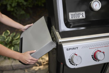 Casavibeo Weber Spirit E-325 gas grill with stainless steel lid, multiple burners, and side shelves for outdoor cooking.
