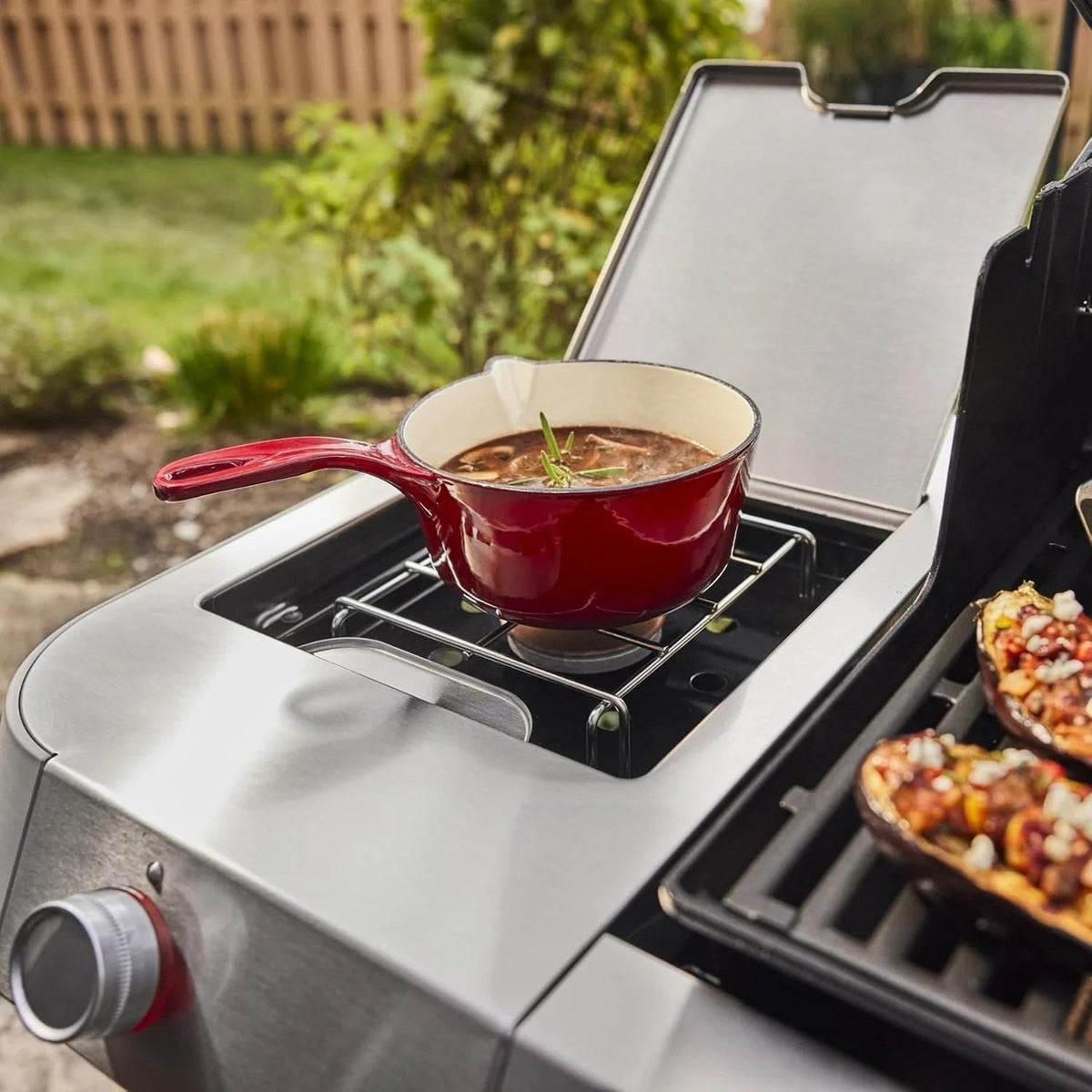 Casavibeo Genesis II E-335 gas grill with stainless steel body, multiple burners, and side shelves for outdoor cooking.