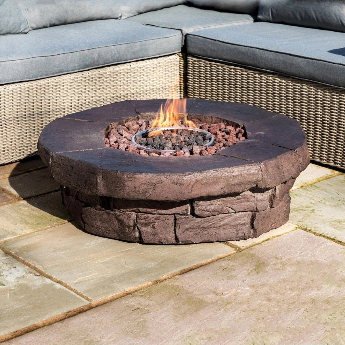 Red Barrel Studio Kimily Propane Outdoor Fire Pit by Casavibeo with a round metal bowl and decorative base, set outdoors.