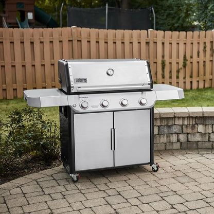 Casavibeo Weber Genesis S-415 natural gas grill with four burners, stainless steel lid, side shelves, and control knobs.