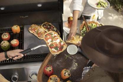 Casavibeo Weber Genesis E-435 gas grill with four burners, stainless steel lid, and side shelves for outdoor cooking.