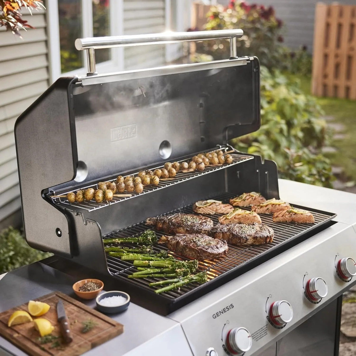 Casavibeo Weber Genesis S-415 natural gas grill with four burners, stainless steel construction, and side shelves, ready for grilling.
