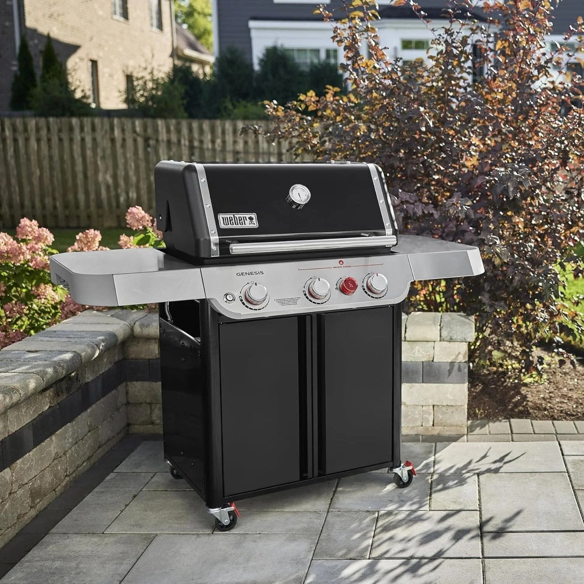 Casavibeo Weber Genesis E-325s gas grill with four burners, stainless steel lid, side shelves, and control knobs for outdoor cooking