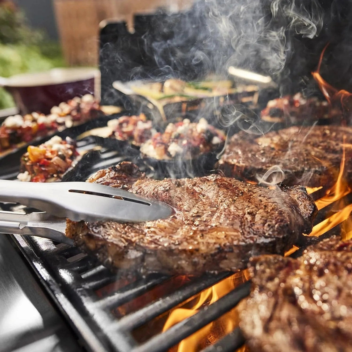 Casavibeo Genesis II E-335 gas grill with stainless steel lid, multiple burners, and side shelves for outdoor cooking.