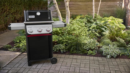 Casavibeo Weber Spirit E-325 gas grill with stainless steel lid, side shelves, and multiple burners for outdoor cooking.