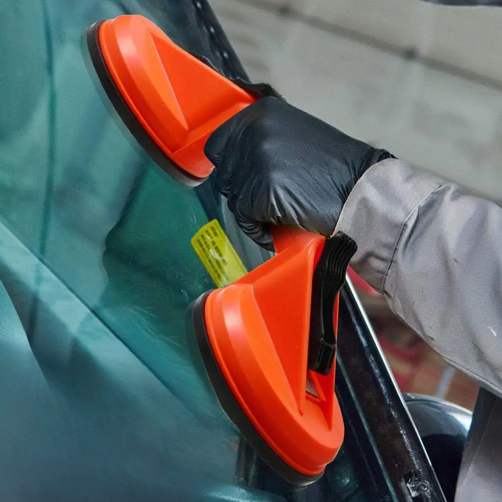 Belro dual suction glass window dent pulling suction cup attached to a smooth glass surface for dent removal.